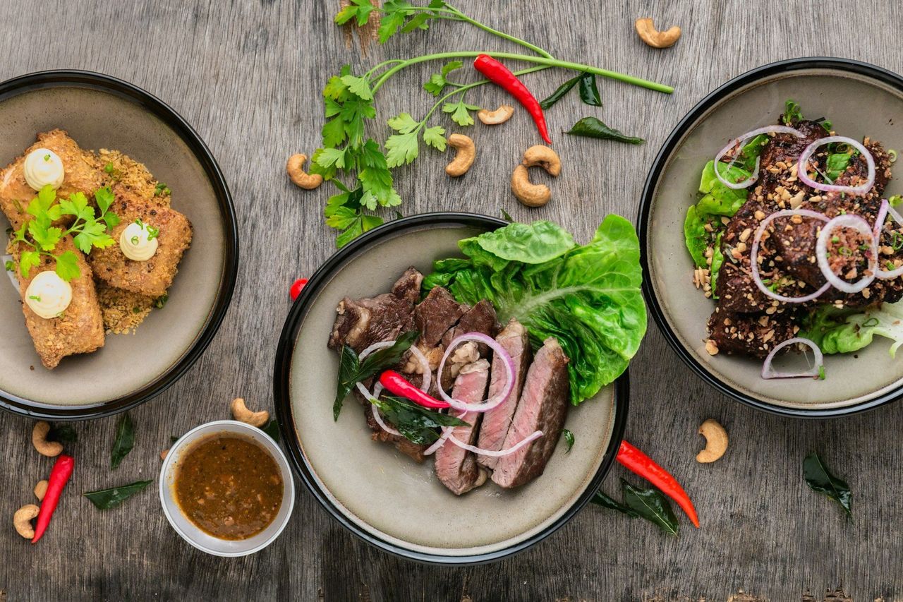 Comida tailandesa. Foto: <a href="https://unsplash.com/@lvnatikk?utm_source=Hoy%20Apps&utm_medium=referral" target="_blank" rel="noopener">Lily Banse</a> (<a href="https://unsplash.com/photos/three-plates-of-asian-food-on-wood-table--YHSwy6uqvk?utm_source=Hoy%20Apps&utm_medium=referral" target="_blank" rel="noopener">Unsplash</a>)